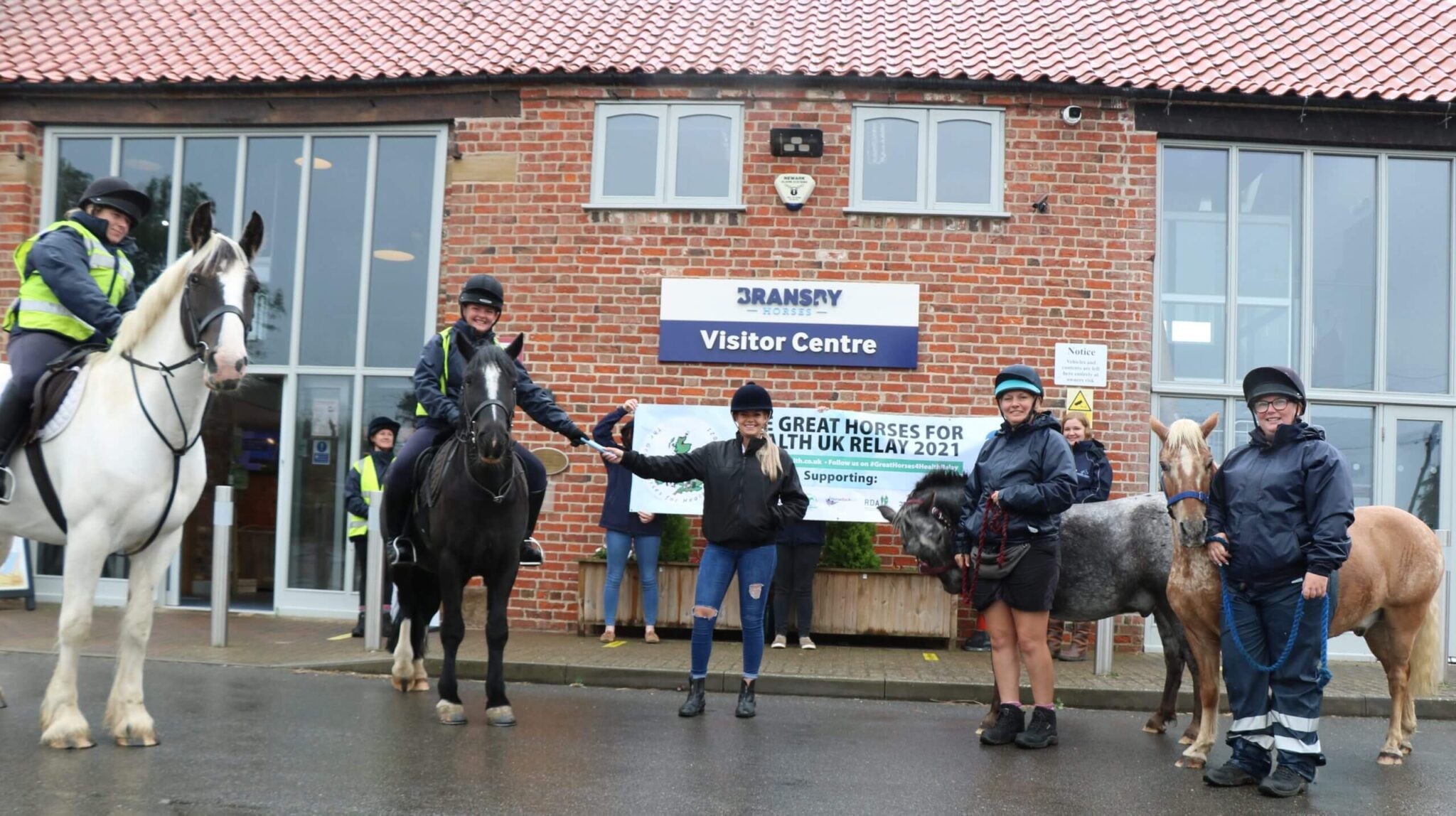 group of horses and riders stood in the bransby horses visitor centre courtyard