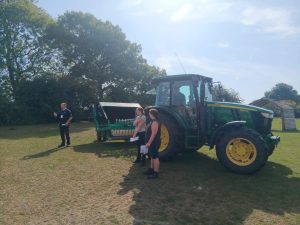 tractor pulling a field sweeper trailer