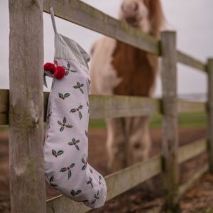 sophie allport holly stocking tied to a fence
