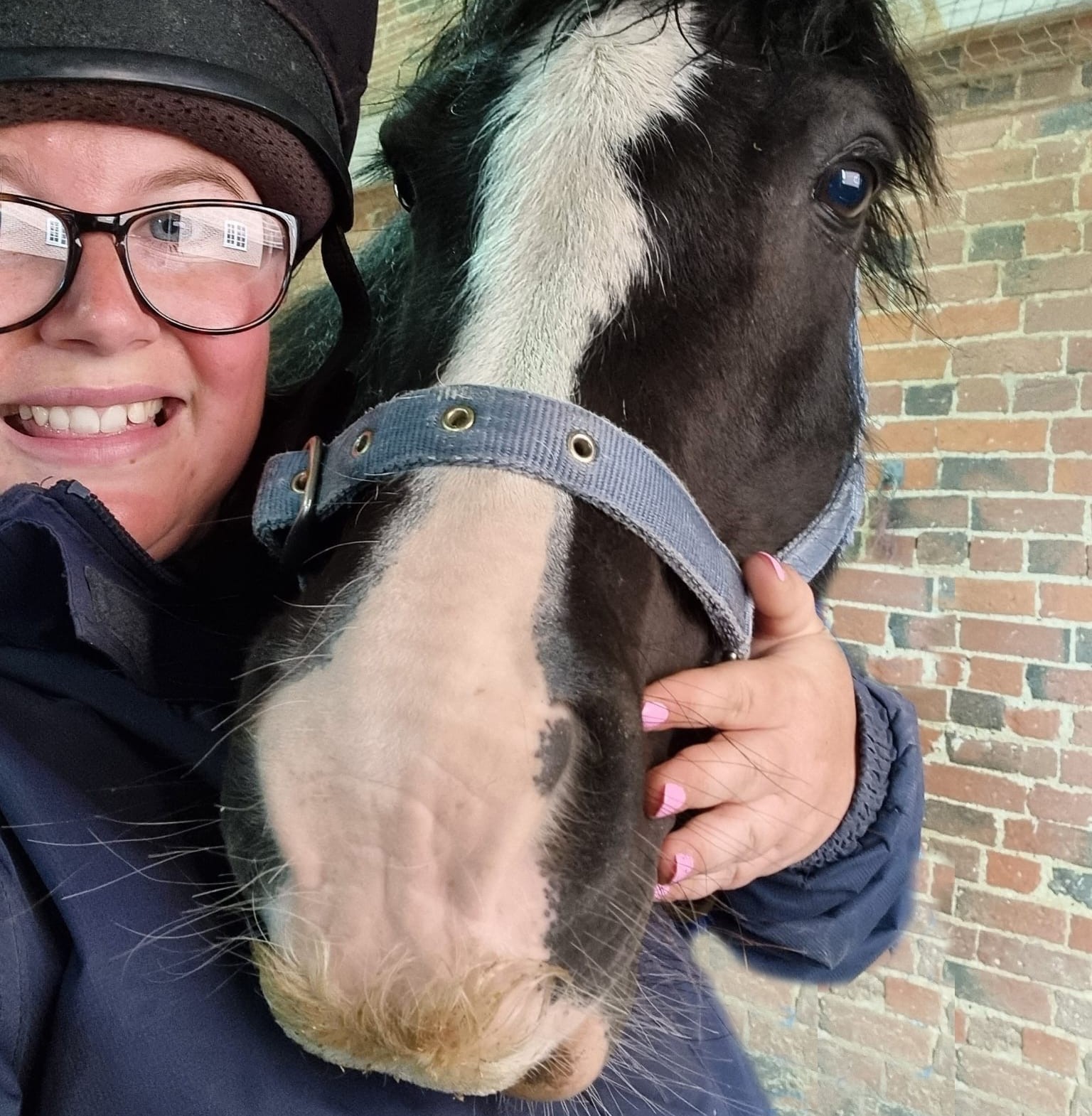 member of staff cuddling with black and white cob