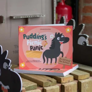 puddings picnic panic book propped up on top of a pile of other books
