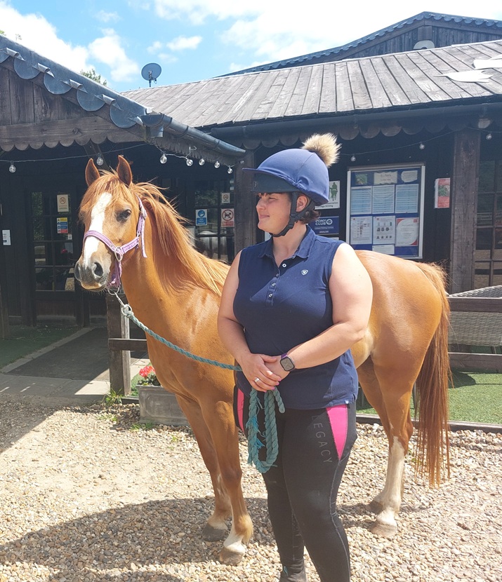 woman stood holding a welsh chestnut pony