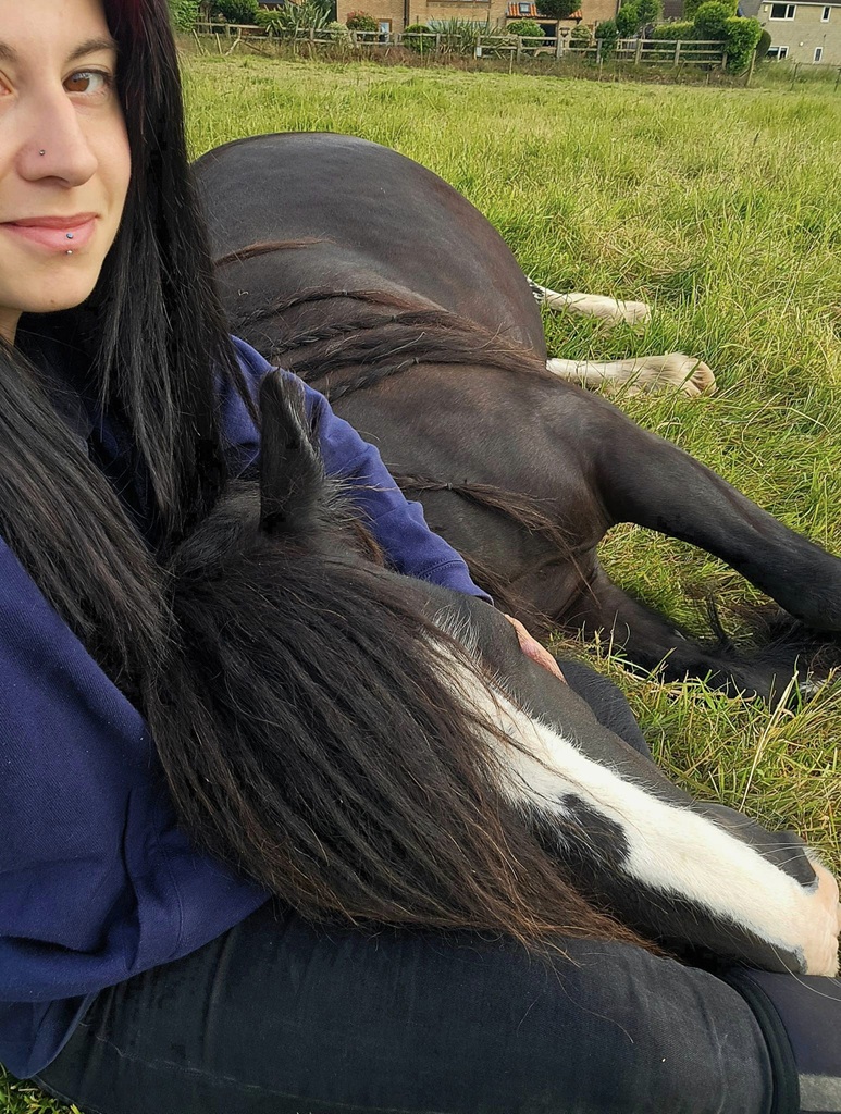 black cob with his head resting on his fosterers lap