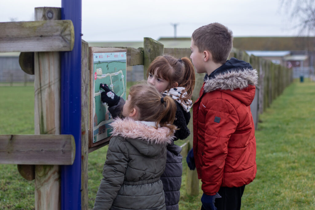 three young children stood looking at a visitor map at Bransby Horses